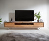 Modern wooden TV stand with two drawers, open shelves, and a metal base, holding a flat-screen TV, décor, and a potted plant.